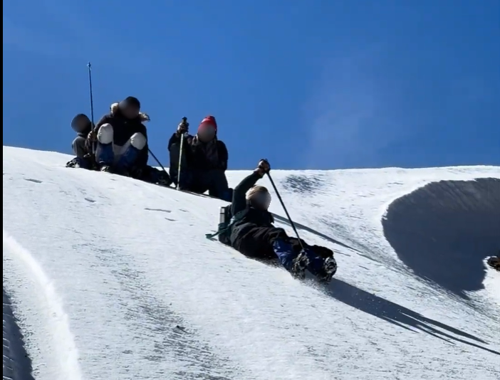 Me sliding down a snowy cliff. I used my pole to brake at times, but it was unpredictable